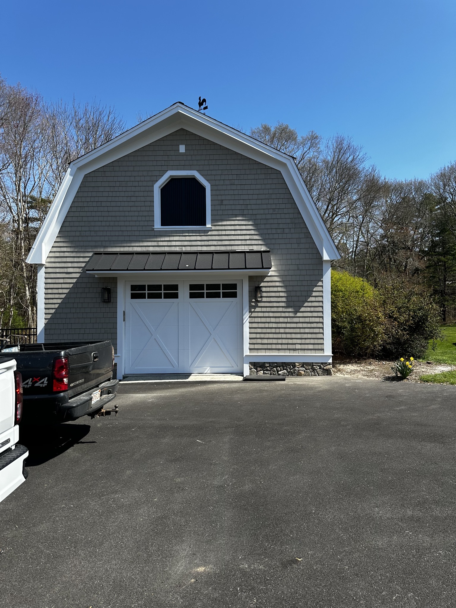 Shingle-clad garage with white trim and a carriage-style door