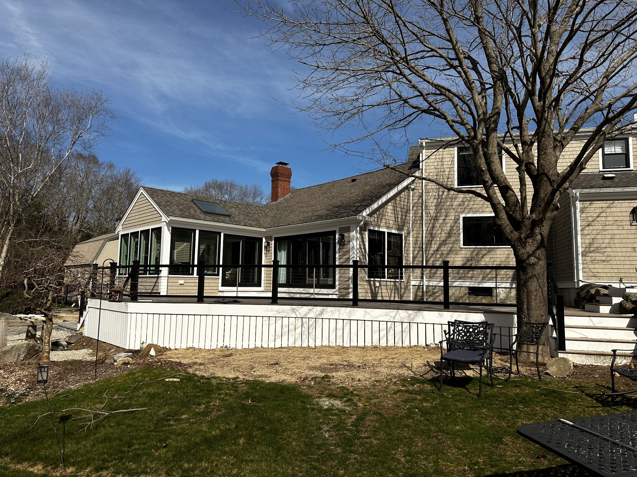 Remodeled shingle home with black-framed windows and a rear deck
